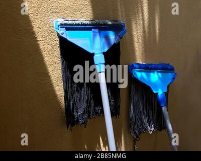 mop, dirty mop blue for washing clean up house slip, mop sunbathe sunlight for dry mop on wall Stock Photo
