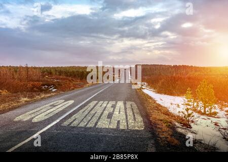 Go ahaid sigh on zhe asphalt symbol of motivation and progress never give up Stock Photo