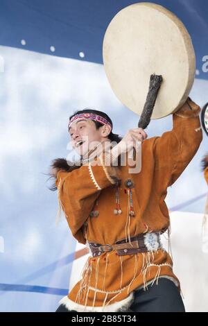 Aboriginal dancer in national clothes of native people emotional dancing with tambourine. Concert Koryak Dance Ensemble Mengo. Kamchatka Peninsula Stock Photo