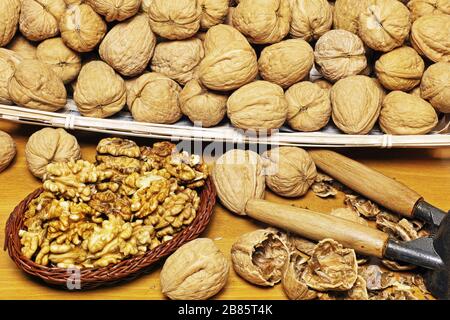 many walnuts in a basket and a little basket full of peeled kernels Stock Photo