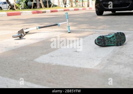 The concept of an accident caused by a child who is playing a scooter and being hit by a car, While using a crosswalk. Stock Photo