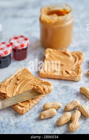 Two tasty peanut butter toasts placed on stone table Stock Photo