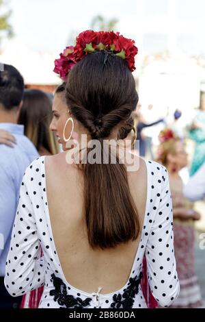 Beautiful woman wearing flamenco dress. Detail of Traditional Spanish Hairstyle. Spanish folklore. April Fair Stock Photo