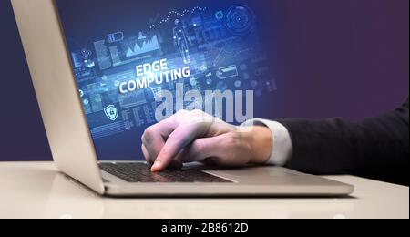 Businessman working on laptop with EDGE COMPUTING inscription, cyber technology concept Stock Photo