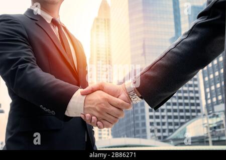 Business concept. deal, joint venture, start up. Businessmen handshaking, on city building background, employment and hiring, enterprisers making good Stock Photo