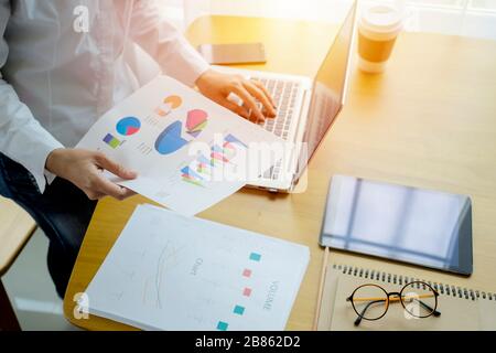 Businessman analyzing investment charts with laptop. working with financial graphs charts online, using business software for data analysis and projec Stock Photo