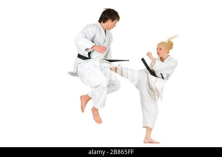 Cute blonde girl and a young cheeky guy karate are engaged in training in a kimono on a white background. Young couple of athletes getting ready for a Stock Photo