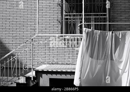 White sheets hanging on the drying rack outside the balcony (Pesaro, Italy, Europe) Stock Photo