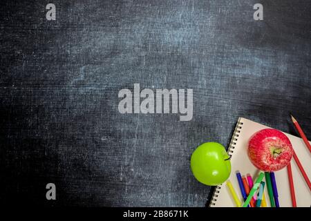 School supplies, Red and green apples on black board background. Back to school concept. Education background concept with copyspace. Back to school. Stock Photo