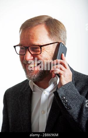 mature bearded executive talking on mobile Stock Photo
