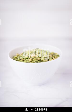 Dry split light green peas in a white cup Stock Photo