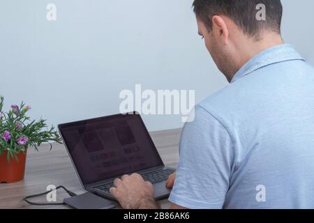 Young man, businessman working on his laptop at home. Freelance. Self-isolation. Quarantine. Home office. Stock Photo
