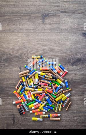 Adelaide, Australia - July 7, 2019: Pile of used household AA and AAA batteries collected for recycling on wooden background Stock Photo