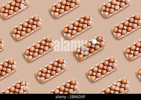 A dozen eggs in a box on the table with one white eggin the pattern. Minimalistic product concept Stock Photo