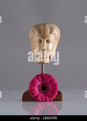 Two pink Gerbera flowers still life study with figure of buddha type statue Stock Photo