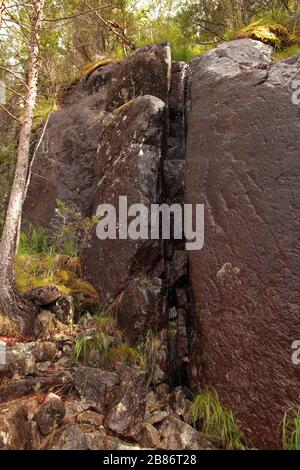 big fault or scratch on the rock. brown rock structure close up. Pile of big granite stones. Texture on the rock surface. Massive stone with scratches Stock Photo