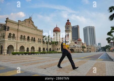 Kuala Lumpur, Malaysia. 20th Mar, 2020. A man wearing face mask walks past the Independence Square in Kuala Lumpur, Malaysia, March 20, 2020. Malaysia on Friday announced 130 newly confirmed cases of COVID-19, bringing the total number in the country to 1,030, said the Health Ministry. Credit: Chong Voon Chung/Xinhua/Alamy Live News Stock Photo