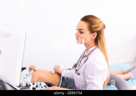 Ultrasound sensor of modern ultrasonic scanner in young woman doctor's hands preparing for a device scan. Helthcare concept. Stock Photo