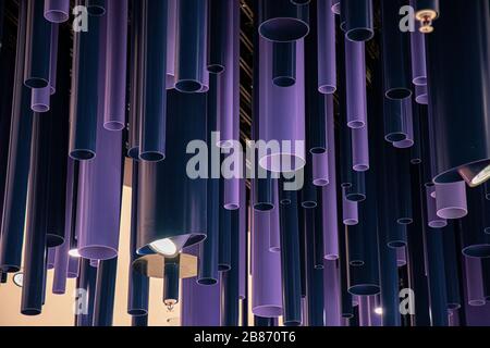 Geometric lines abstract background. Purple and blue cylinder pipes of different diameters and lengths. Unusual decorations. Dark violet color pattern Stock Photo