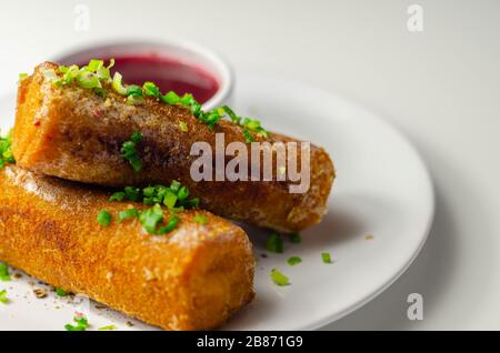 Delicious croquettes with sauerkraut and mushrooms served with hot red borscht, Eastern European cuisine Stock Photo