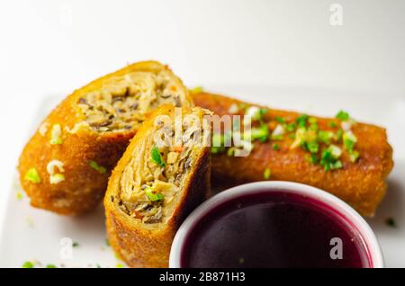 Delicious croquettes with sauerkraut and mushrooms served with hot red borscht, Eastern European cuisine Stock Photo