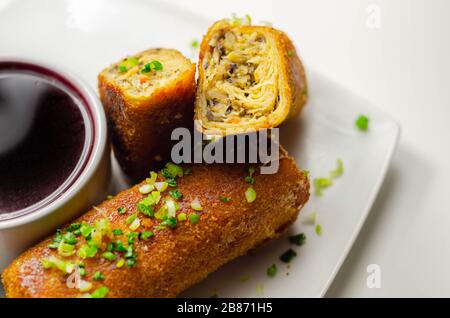 Delicious croquettes with sauerkraut and mushrooms served with hot red borscht, Eastern European cuisine Stock Photo