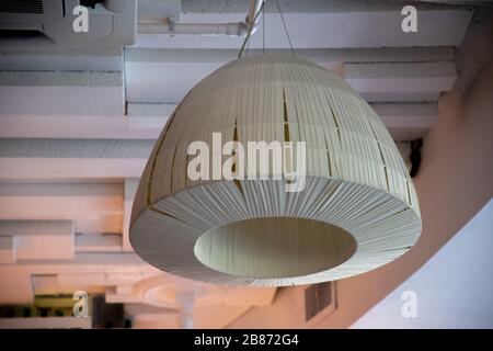 Simple white lampshade of minimal style ceiling lamp. Geometric 3D shape on textured wooden planks background. Stock Photo