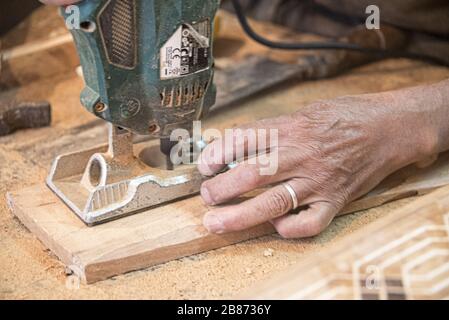 Essaouria, Morocco - September 2017: Carpenter using power tool - close up of hands Stock Photo