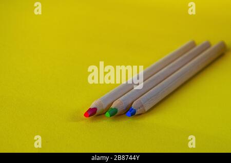 multi colored pencils on a yellow background Stock Photo
