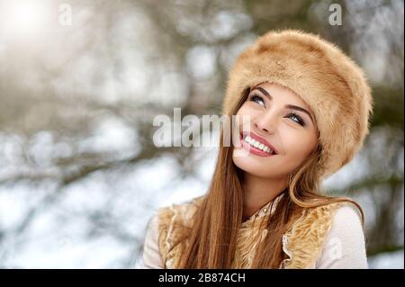 Making a wish! Surprised beautiful woman looking at something. Delighted and excited smiling winter girl portrait. Copy space, close up Stock Photo