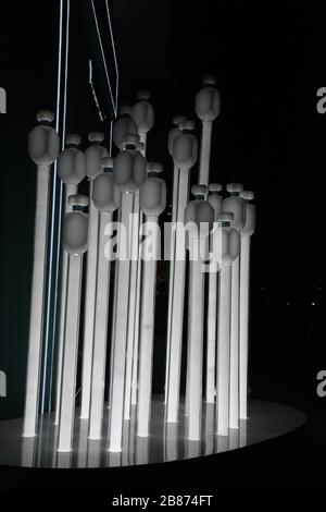 Geometric lines of shiny light bulbs in shape of long white installations on black background. Unusual lighting equipment. Modern abstract backdrop. Stock Photo