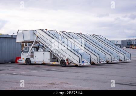 A row of gangways for boarding and alighting passengers from an airplane parked at the airport Stock Photo