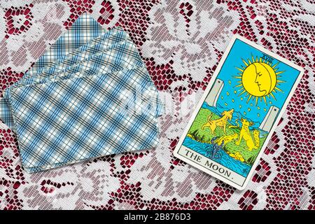 Rider Tarot Cards designed by Pamela Colman Smith under supervision of Arthur Edward Waite on cloth with The Moon tarot card upturned Stock Photo