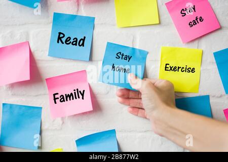 Hand Stay home words in colored notes Stock Photo