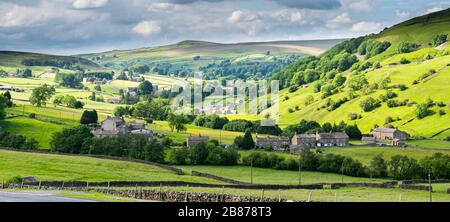 A Summer view across Langthwaite to the meadows, woods and moors of Arkengarthdale, one of the Northern valleys in the Yorkshire Dales National Park Stock Photo