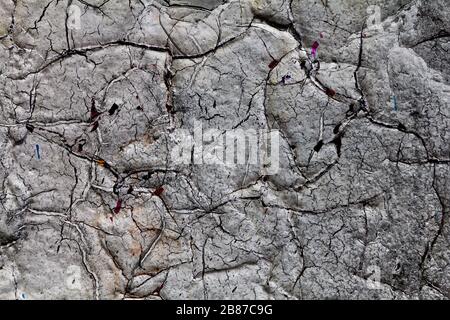 Surface texture with white paint and cracks on concrete wall with strong surface structure. For abstract backgrounds. Germany Stock Photo