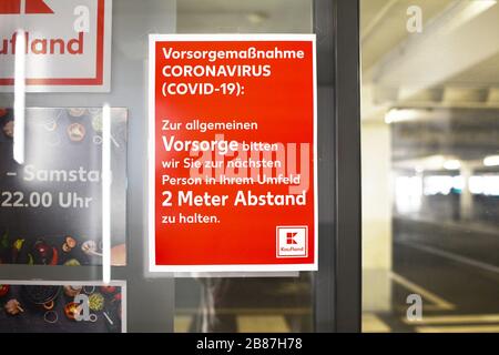 Red information sign at entrance of German groceries store informing customers of rules to keep 2 meters distance to other customers Stock Photo
