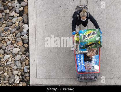 Alexandira, United States. 20th Mar, 2020. A woman pushes a cart full to groceries and supplies as the leaves a Costco Warehouse in Alexandria, Virginia on March 20, 2020. Shoppers are contenting to buy and bulk as the COVID-19, coronavirus, pandemic continues to expand in the United States. Photo by Kevin Dietsch/UPI Credit: UPI/Ģ����ý Live News Stock Photo