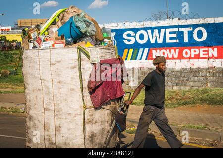 Soweto, Johannesburg, South Africa - December 3,2019 - a garbage collector pulls a cart to a dump. Recycling is a major shadow economy in South Africa Stock Photo