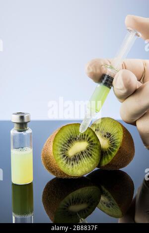 Liquid is injected into a kiwi, symbol image genetic manipulation, Austria Stock Photo