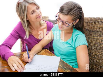 pretty teen girl doing its homework in complicity with a female teacher Stock Photo