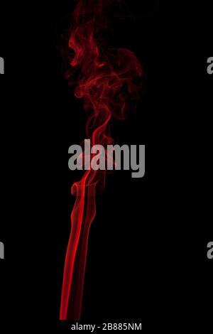 Abstract red smoke swirling on a black background. Stock Photo