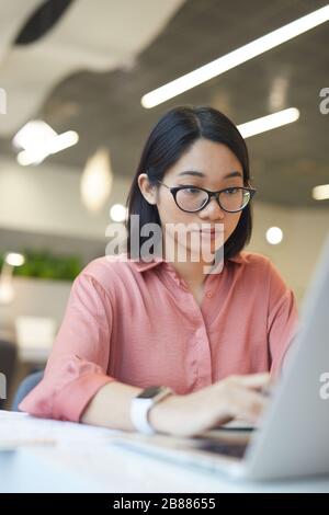 Portrait of young Asian woman using laptop while studying in cafe Stock Photo