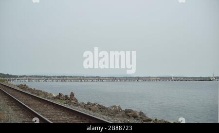Horizon line of the pier near a train track in White Rock BC Stock Photo