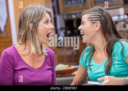 mother and daughter sharing a moment of complicity and laughing Stock Photo