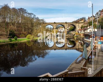 The Victorian railway viaduct reflected in the River Nidd in early spring at Knaresborough North Yorkshire England Stock Photo