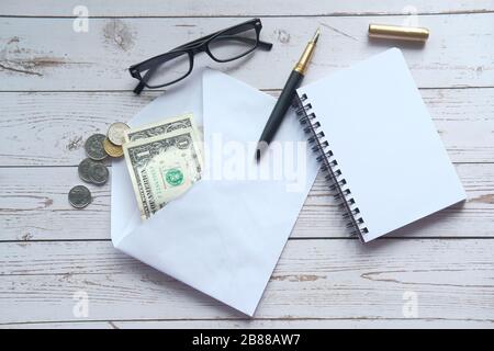 top view of cash envelope and notepad on table. Stock Photo