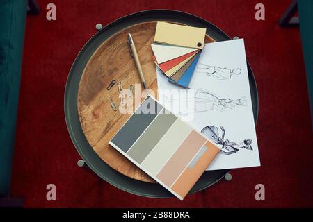 High angle view of design sketches and colored patterns lying on wooden table Stock Photo