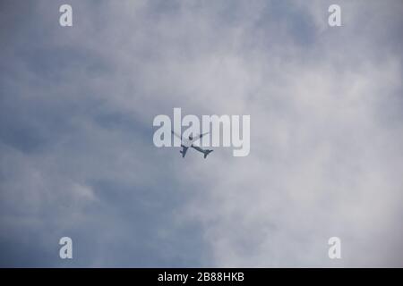 A single airplane has just taken off from Copenhagen airport and is seen from below as it enters the clouds in a bright summer day Stock Photo