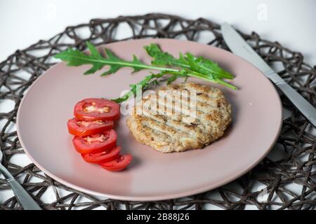 juicy fried meat cutlet with tomato on a plate Stock Photo